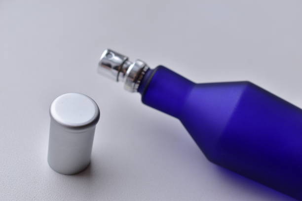 istock Purple glass bottle with perfume cologne on a white background 1304503778