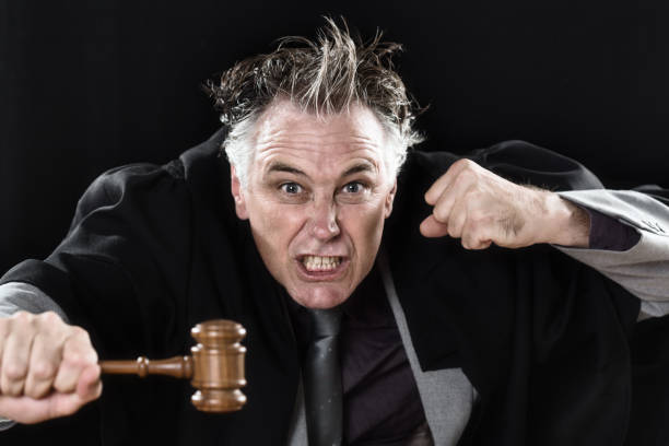 Judge loses his temper and rages at you, shaking his fist and waving his gavel Angry judge loses control of himself and expresses his fury at you, with clenched fist and gavel. punching one person shaking fist fist stock pictures, royalty-free photos & images