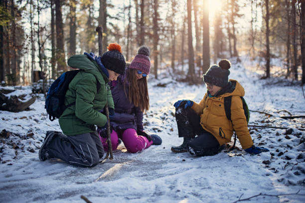 istock Kids playing with frozen puddle on winter day 1304504241