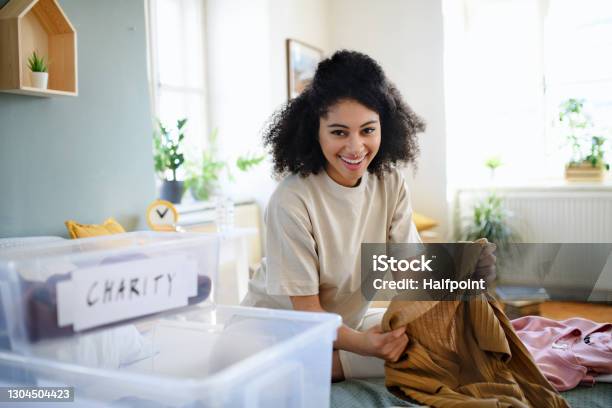 Young Woman Sorting Wardrobe Indoors At Home Charity Donation Concept Stock Photo - Download Image Now