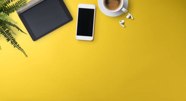 istock Flat lay top view office desk working space with tablet on yellow background. Copy space. 1304505281