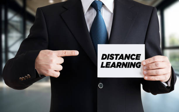 istock Businessman shows a card with the message distance learning. E-learning or online education 1304507807