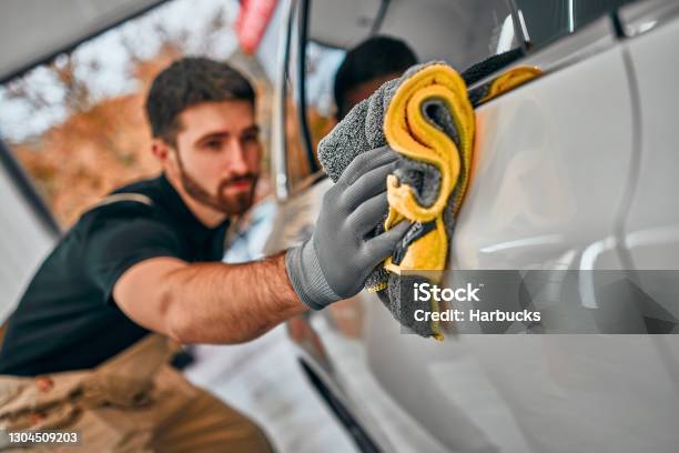 Man After Washing Wipes White Car With A Rag At Car Wash Stock Photo - Download Image Now