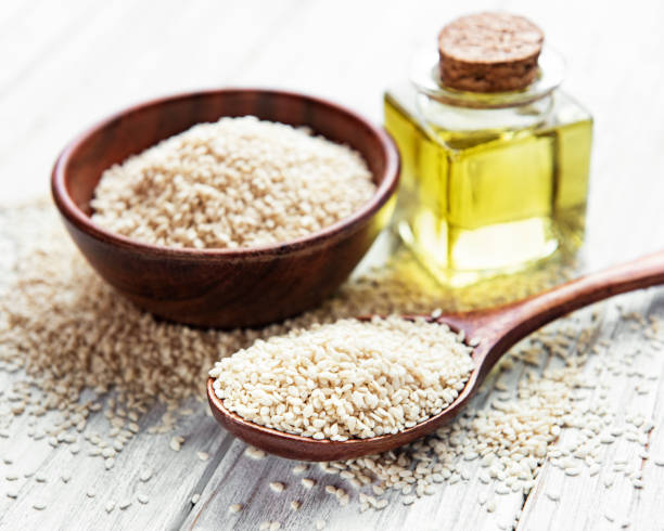 istock Sesame oil and seeds on a rustic table. 1304509631