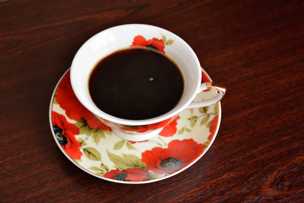 Poppy cup of black coffee on the saucer.