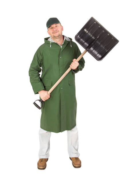 istock A man in a long raincoat with a shovel. 1304510881