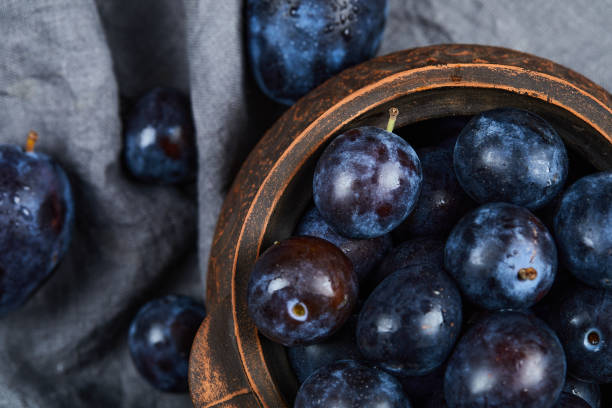 istock Garden plums in a bowl on gray tablecloth 1304512056