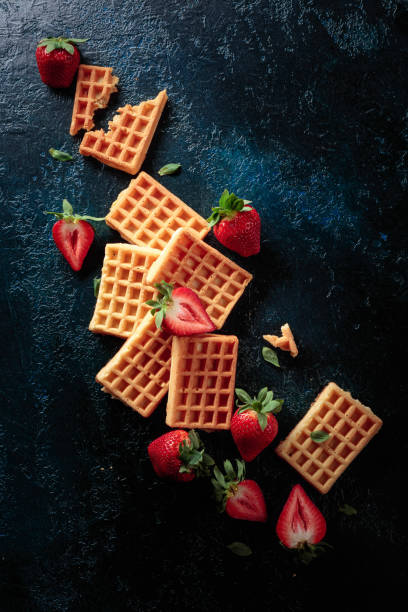 istock Waffles with fresh juicy strawberries on a dark blue background. 1304513043
