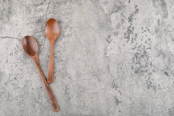 istock Two wooden spoons for kitchen placed on marble background 1304516803