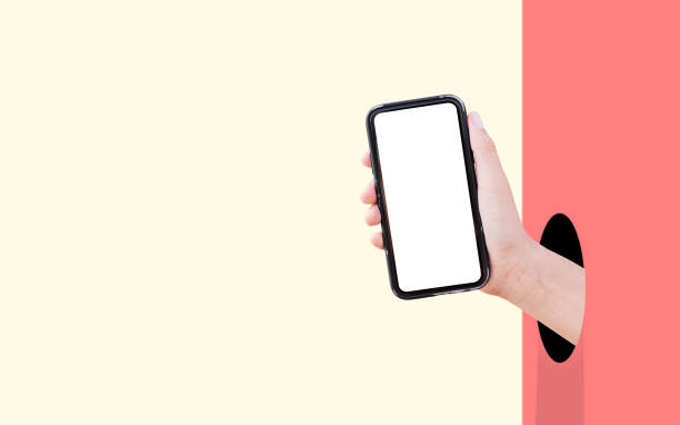 istock Smartphone with mockup in hand from hole against two backgrounds of pastel red and yellow colors. 1304517543