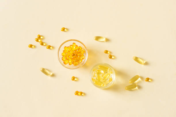 capsule riempite d'olio (softgel) - vitamin e cod liver oil vitamin pill capsule foto e immagini stock