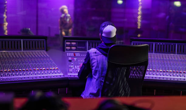 Female Vocalist And Sound Engineer Working In Studio