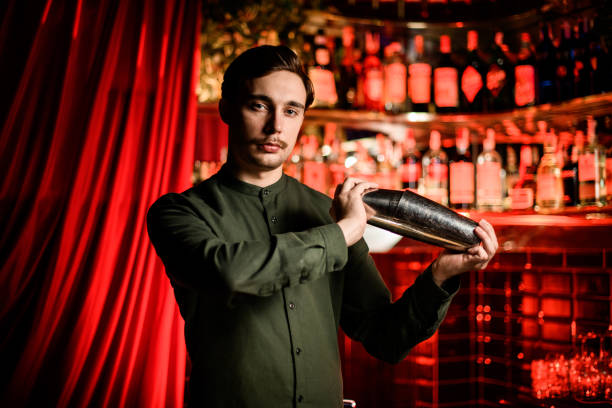 istock view of attractive man bartender standing with steel shaker in his hands 1304520372