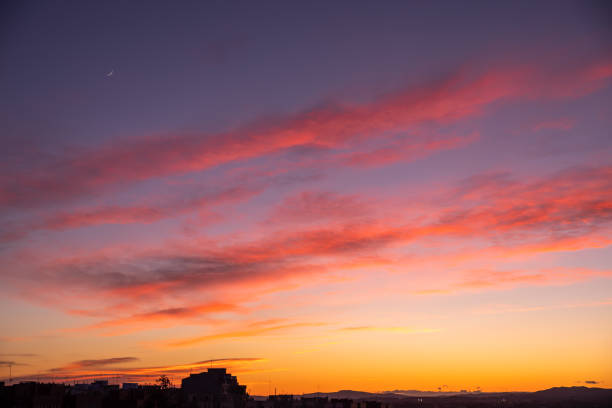 New moon in a Twilight Purple And Golden  over the city silhouette