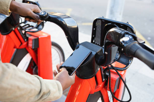 persona tomando una bicicleta en una plataforma de alquiler de bicicletas. - bikeshare fotografías e imágenes de stock