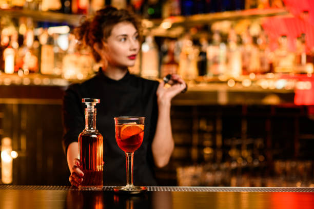 vista de cristal con cóctel en bar y botella con bebida en mano de camarero cercano - gin decanter whisky bottle fotografías e imágenes de stock