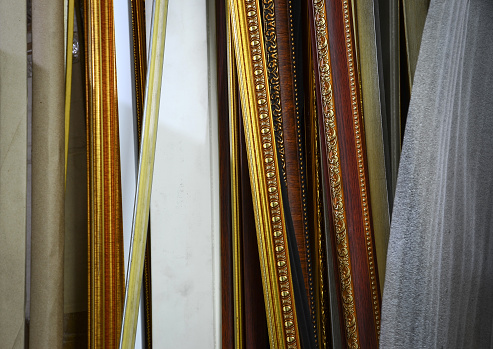 Wooden frame, golden lines, antique patterns, brown in many ways, arranged together as a tool for making picture frames in a shop or factory to decorate the building for beauty.The wooden frame, golden line, antique pattern, brown, many types are arranged together to make a picture frame