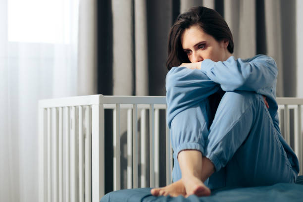 несчастная женщина, страдающая послеродовой депрессией - human pregnancy depression sadness women стоковые фото и изображения