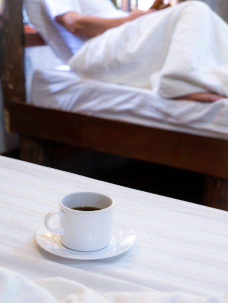 istock White Coffee Mug Rests on The White Mattress behind The Man Sitting 1304522810