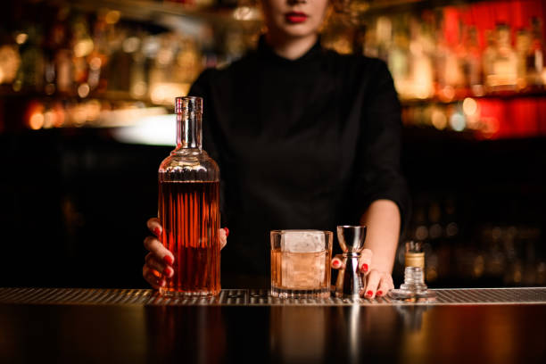 бутылка ликера и стекла с коктейлем и джиггером в баре - gin decanter whisky bottle стоковые фото и изображения