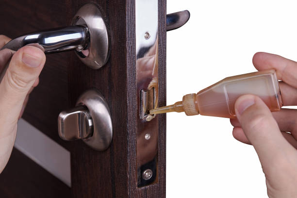 adjusting inner door lock using lubricating oil. indoors. fixing door squealed domestic problem adjusting inner door lock using lubricating oil. indoors. fixing door squealed domestic problem. door chain stock pictures, royalty-free photos & images