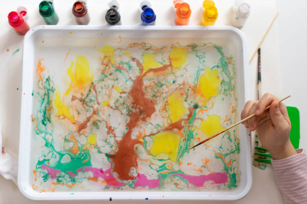 istock childrens hands drawing tree with paints on water 1304523833
