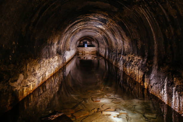 istock Flooded vaulted sewer tunnel with water reflection 1304525221