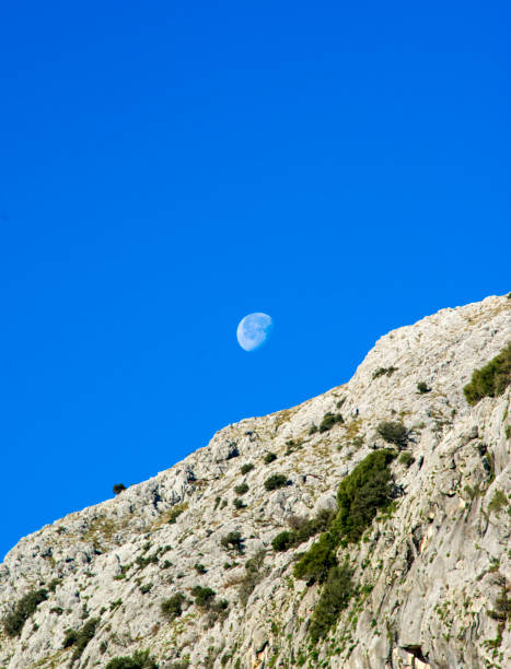 istock Montain landscape with the moon and blue sky 1304526444
