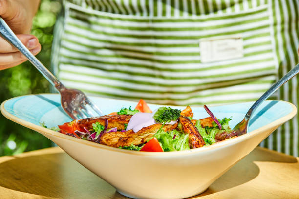 istock Man taking salad with forks from wooden table 1304528570