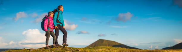istock Young hikers looking over mountain landscape panorama at sunset 1304530891