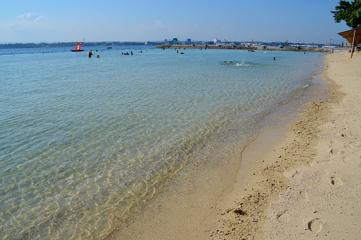 Transparent sea at Samal island, people enjoying swimming at Paradise beach resort, Mindanao, Philippines.