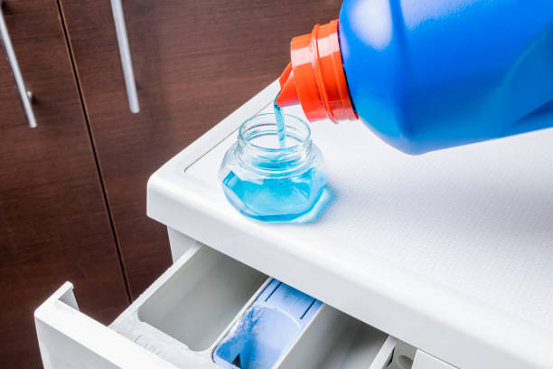 istock laundry using liquid detergent concept. detergent product cap on washing machine. hygiene housework conceptual 1304535897