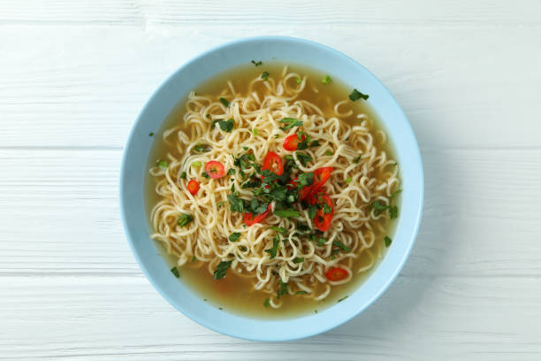 istock Plate with noodles soup on white wooden background 1304536144