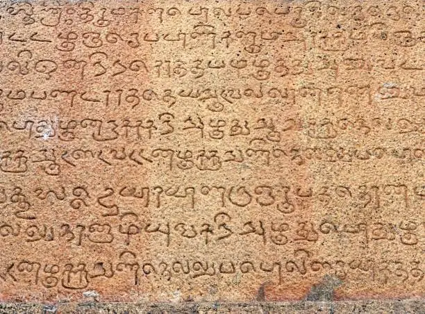 Photo of Inscriptions of Tamil language carved on the stone walls at Brihadeeswarar temple in Thanjavur. Indian rock relief art of stone inscriptions in temples.