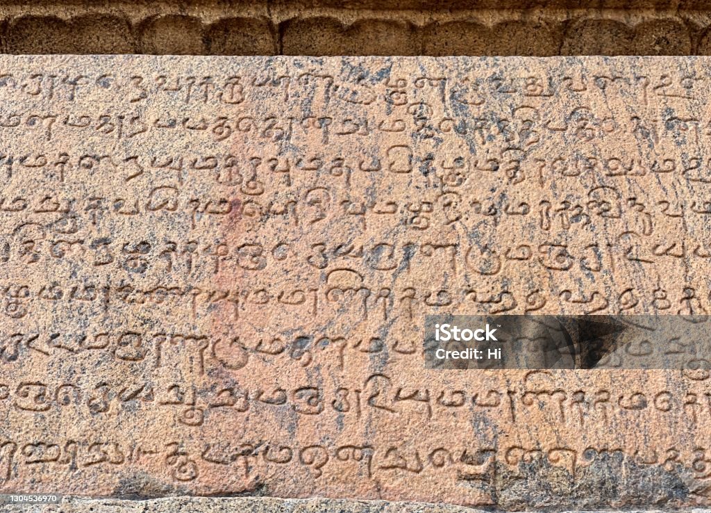 Inscriptions of Tamil language carved on the stone walls at Brihadeeswarar temple in Thanjavur. Indian rock relief art of stone inscriptions in temples. In Brihadeeshwara temple, many of wall inscription found throughout the temple walls. All these inscription made by Raja Raja chola to honour every people who works for the temple. Alphabet Stock Photo