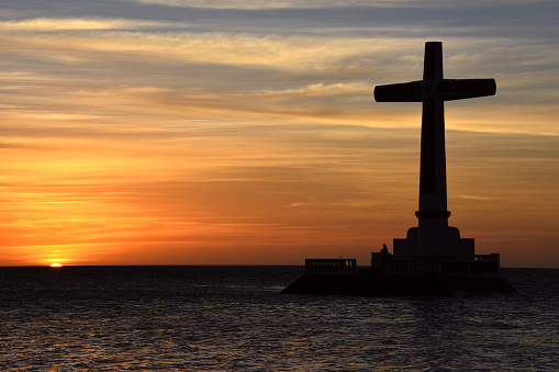 silhouette of a cross and a cypress at sunset