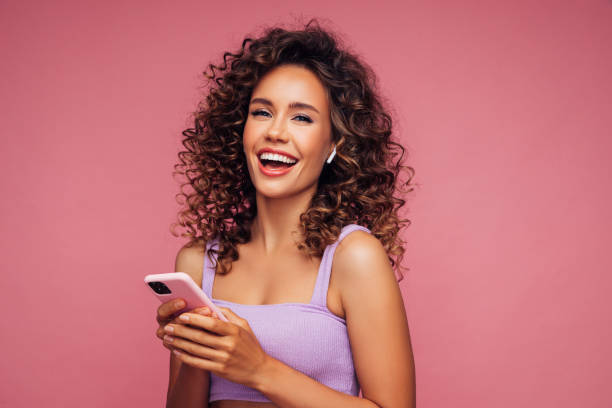 istock Woman in wireless earbuds holding smartphone 1304537613