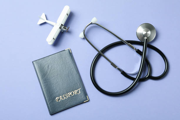 istock Passport, stethoscope and toy plane on violet background 1304540205