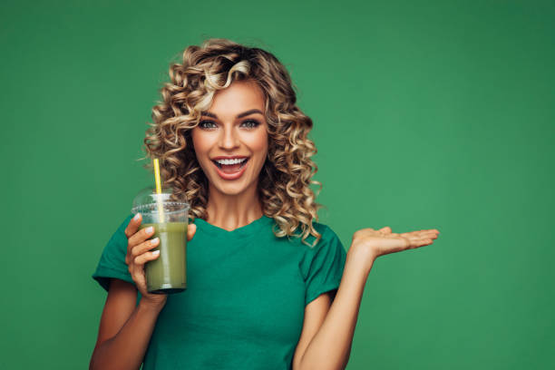 istock Beautiful woman drinking smoothie 1304540216
