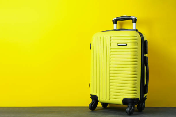 istock Travel bag on yellow background, space for text 1304540279