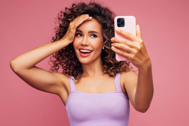 istock Woman in wireless earbuds making selfie 1304540627