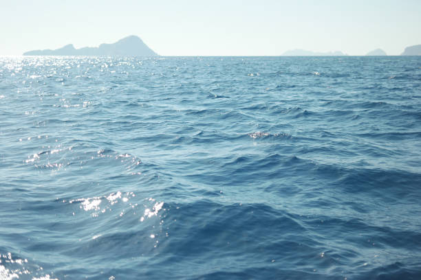 Beautiful seascape and mountain view on the horizon. Blue sea waves with islands view on a summer day. Picturesque marine background.