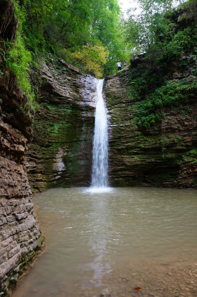 istock Waterfall in a mountainous and wooded area. 1304541465