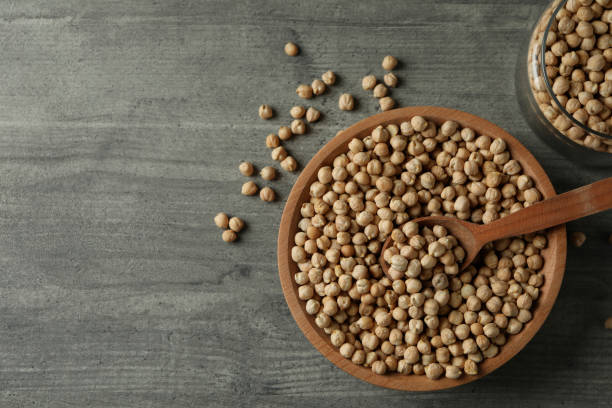 istock Bowl, jar and spoon with chickpea on gray table 1304541518