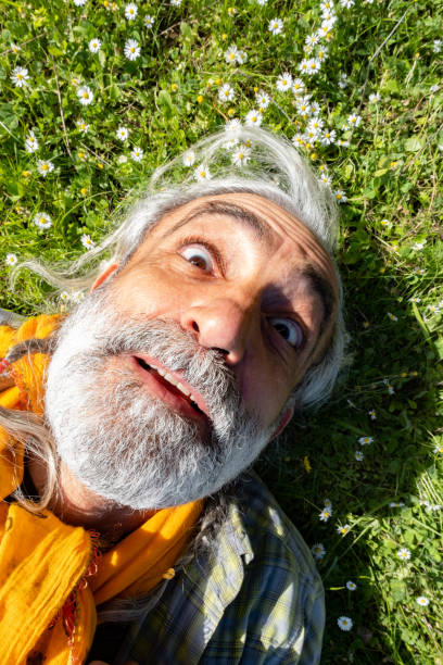 istock 60-year-old man in nature lying on the grass 1304543410
