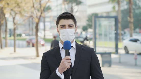 TV reporter wearing a face mask.