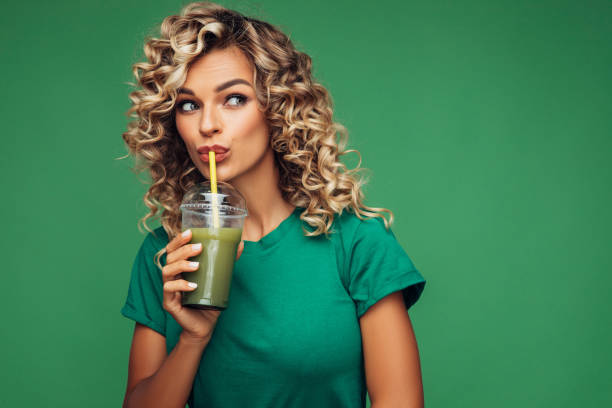 istock Beautiful woman drinking smoothie 1304543814