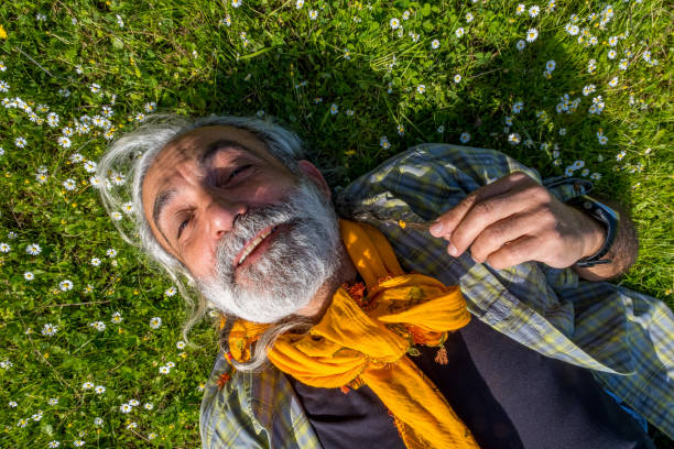 istock 60-year-old man in nature lying on the grass 1304543824