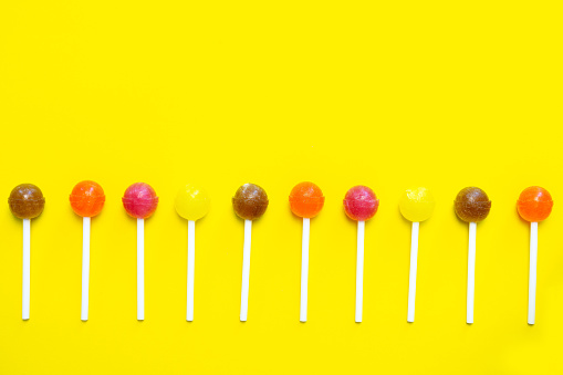 Colorful lollipops on a yellow background.