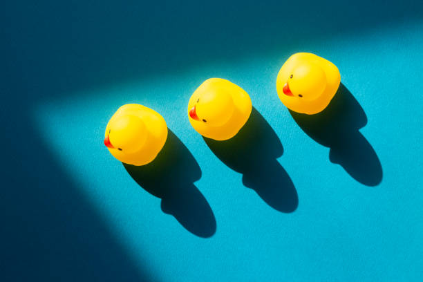 istock Yellow rubber duck doll on mint blue background 1304548727